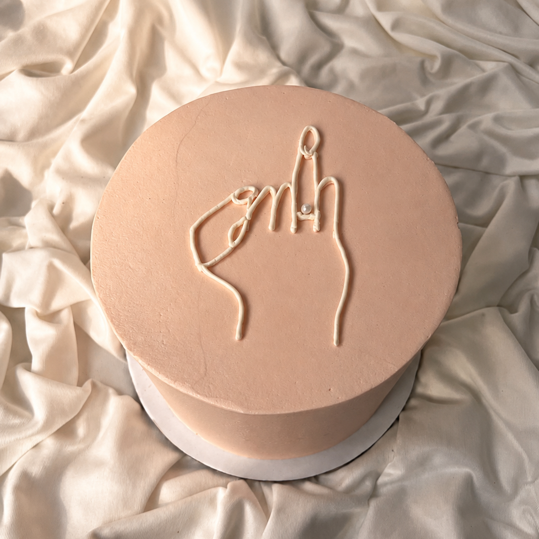 Round beige object with a hand gesture design on a textured beige surface