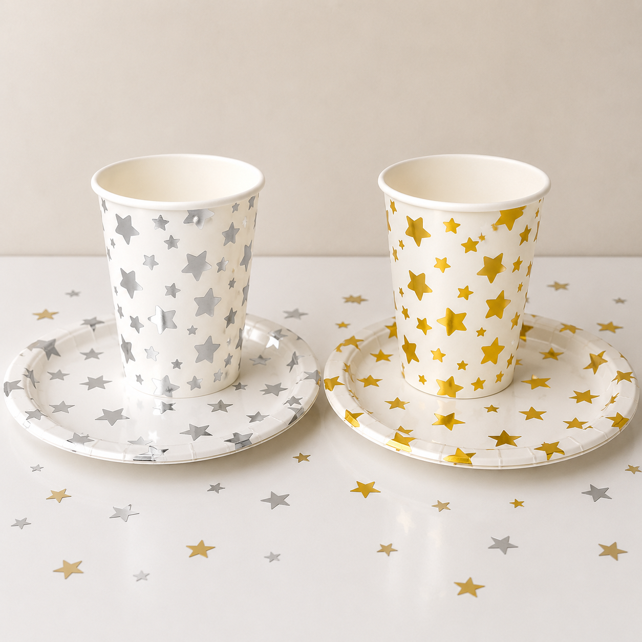 Two paper cups with star patterns on a matching saucer set against a white background.