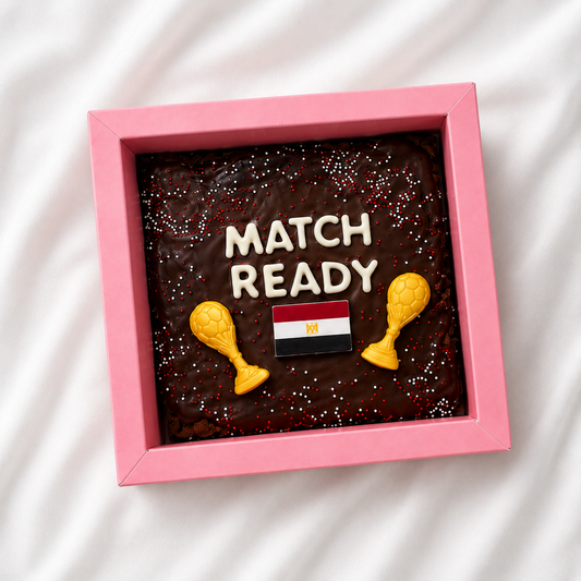 Decorative box with 'Match Ready' text, maracas, and an Egyptian flag on a white fabric background.
