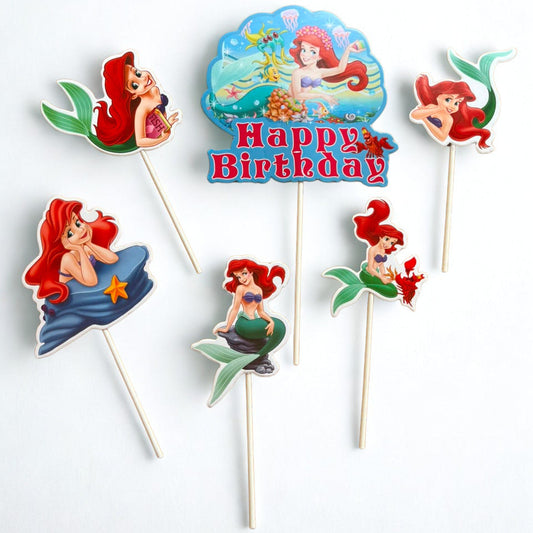 A set of Ariel-themed mermaid birthday cake toppers on wooden sticks, featuring various illustrations of Ariel and a central 'Happy Birthday' sign, displayed on a clean white background.