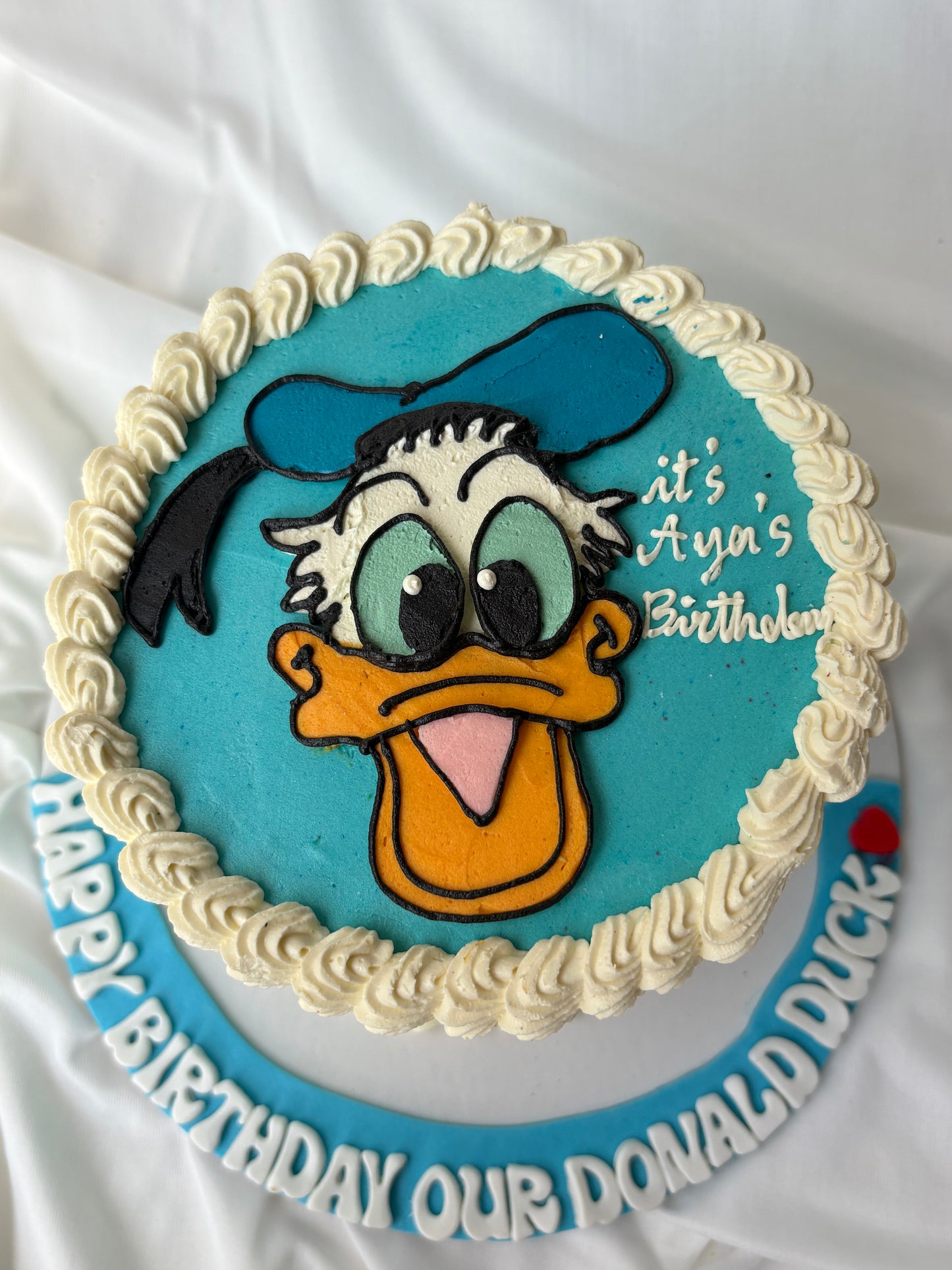 Birthday cake with Donald Duck design on a white background