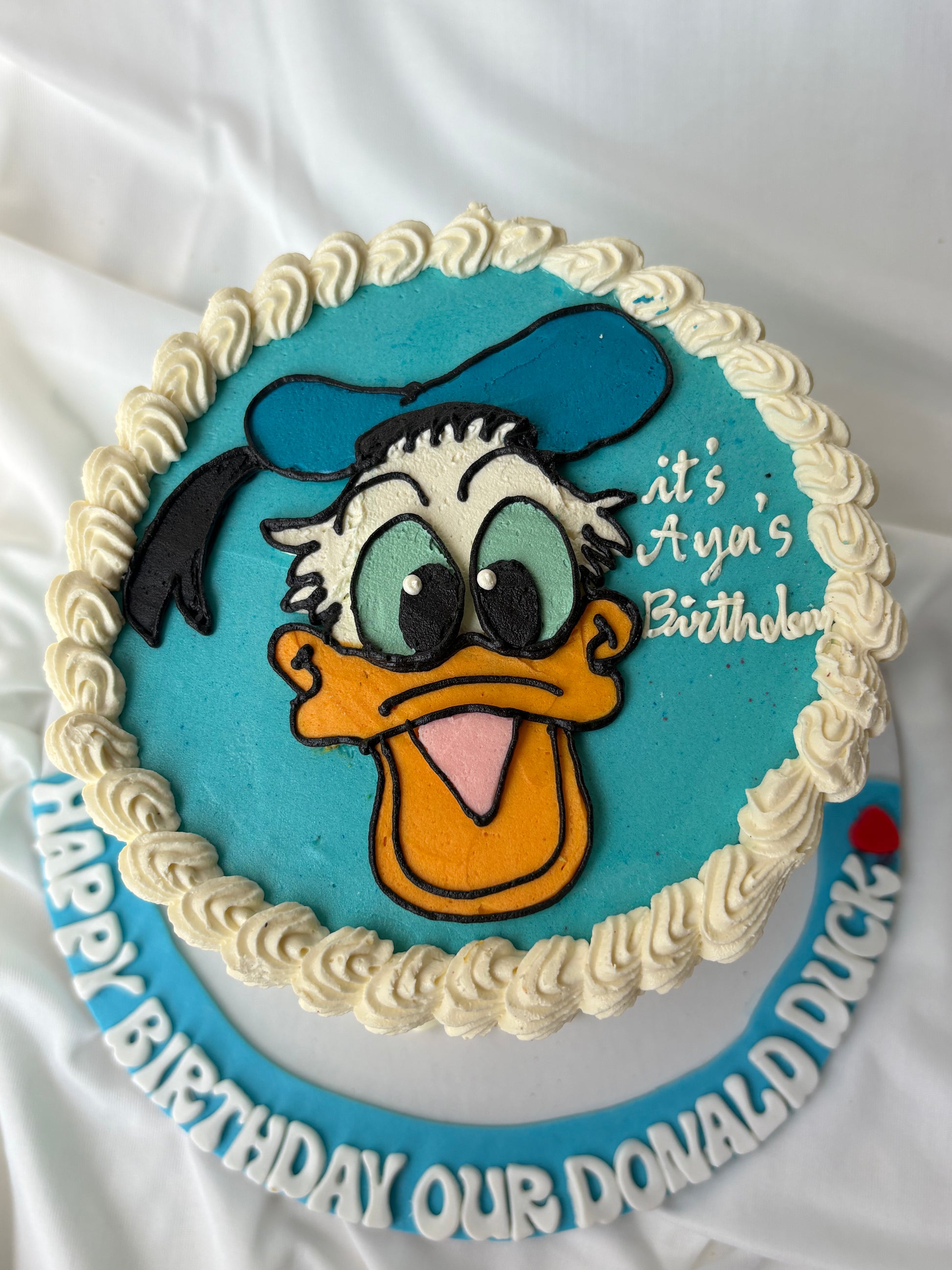 Birthday cake with Donald Duck design on a white background