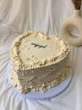 Decorative cake with 'engaged' text on a white background