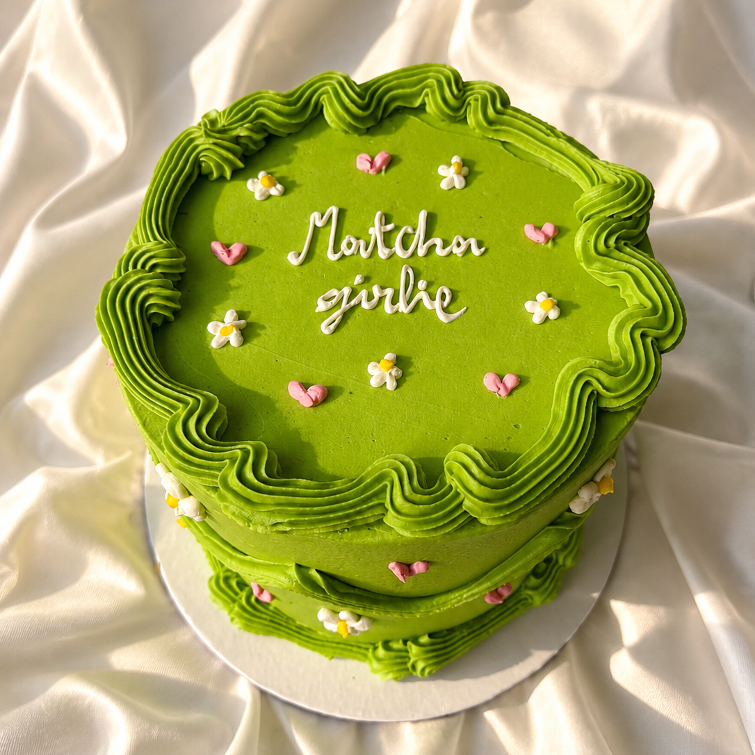 Green cake with decorative elements on a white fabric background