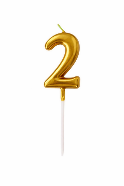 Gold number '2' birthday candle on a white background