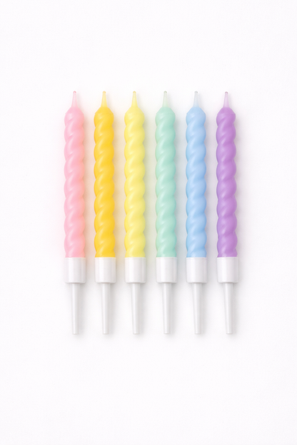 Set of six pastel-colored candles on a white background