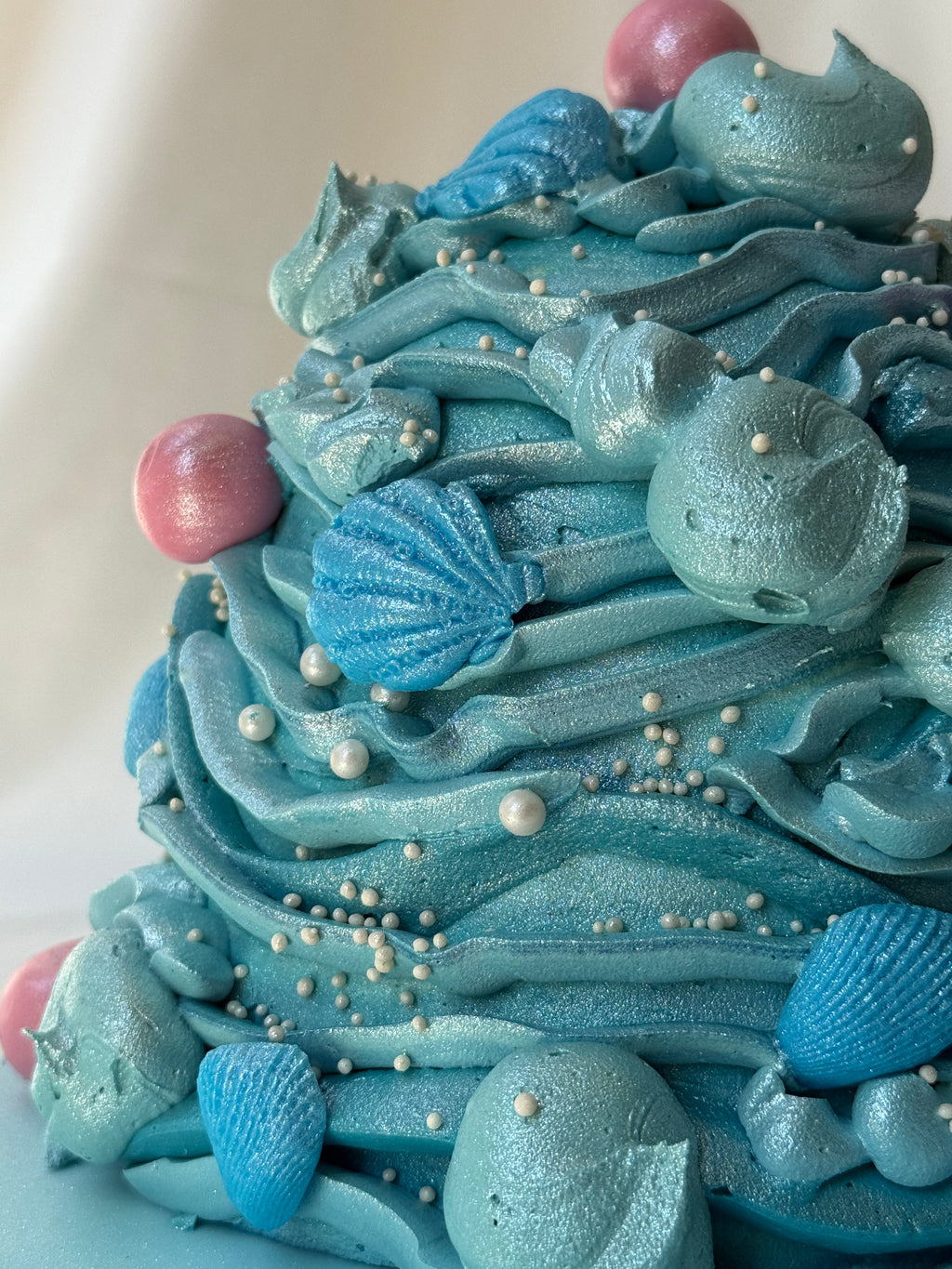 Close-up of a blue cake with decorative elements on a white background