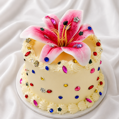 Decorative cake with pink flower and colorful gemstones on a white background