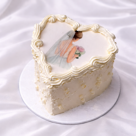Heart-shaped cake with a bride and groom design on a white background