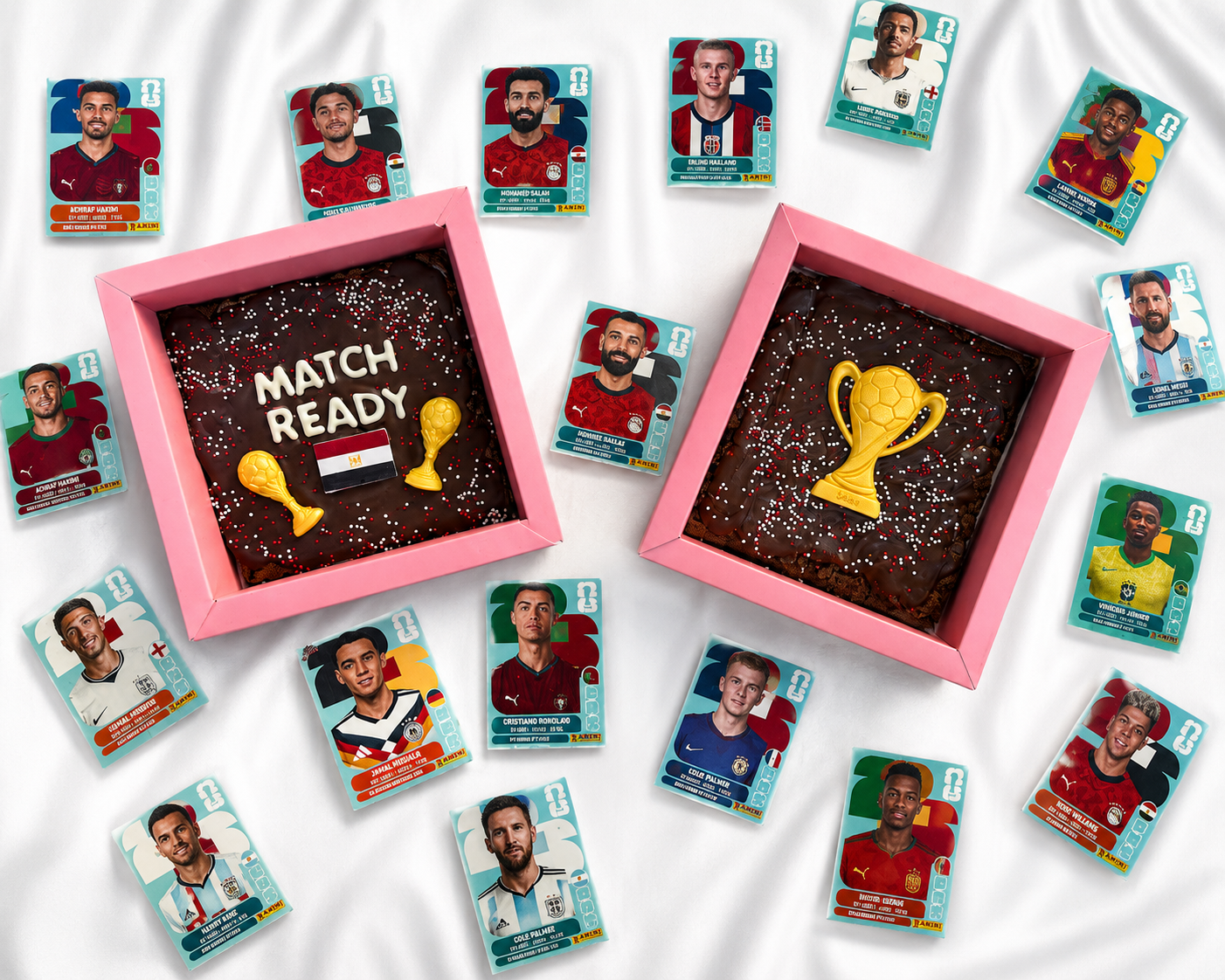 Collection of football player cookies with two chocolate brownies featuring trophy designs on a white background.